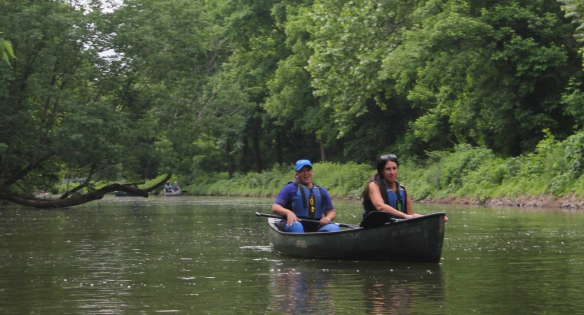 two people paddle a canoe on a wilderness expedition with outward bound
